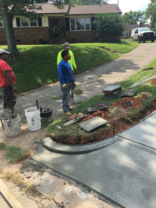 Workers finishing the edge and curb of a concrete driveway for Allen's Concrete Finishing in Rock Hill, SC.