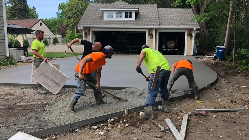 Workers installing a new concrete driveway for a home by Cervantes Concrete Llc in Caledonia, WI.