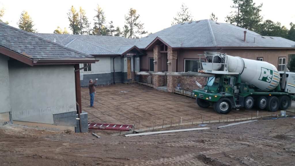 A concrete mixer truck pouring a new residential driveway for Element Construction Company in Colorado Springs, CO.