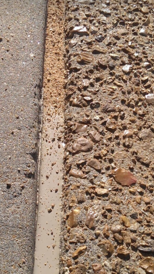 A close-up of a concrete expansion joint with fresh sealant applied by Concrete Crack Repair and Sealer - DrivewayDr.com in Saint Louis, MO.