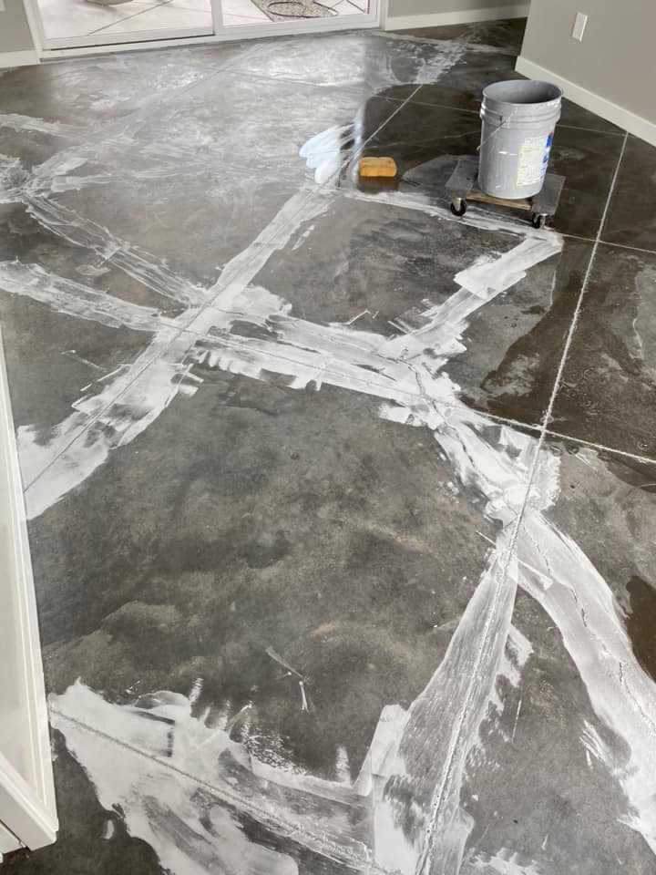 A concrete floor being sealed or finished, showing white material applied, by Manning's Attention 2 Detail Painting, LLC in Tucson, AZ
