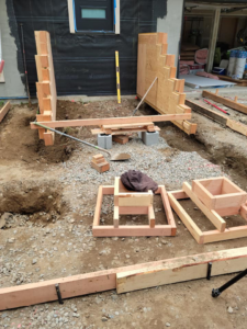 Setting up wooden formwork for a concrete foundation or footing by Smith Finishes LLC in Everett, WA.