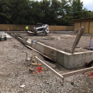 A construction site showing concrete foundation forms and a bobcat, handled by Complete Concrete of Indy, Inc. in Fishers, IN.