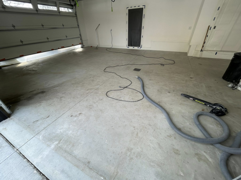 Close-up of concrete garage floor grinding and preparation with specialized equipment by DuraFloor Epoxy Pros in Akron, OH.