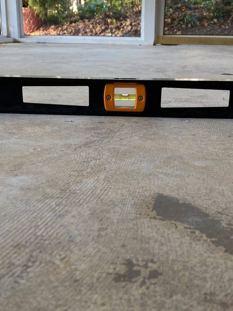 A spirit level showing a perfectly level concrete surface, demonstrating quality handyman work by Concrete Uprising in Cary, NC.