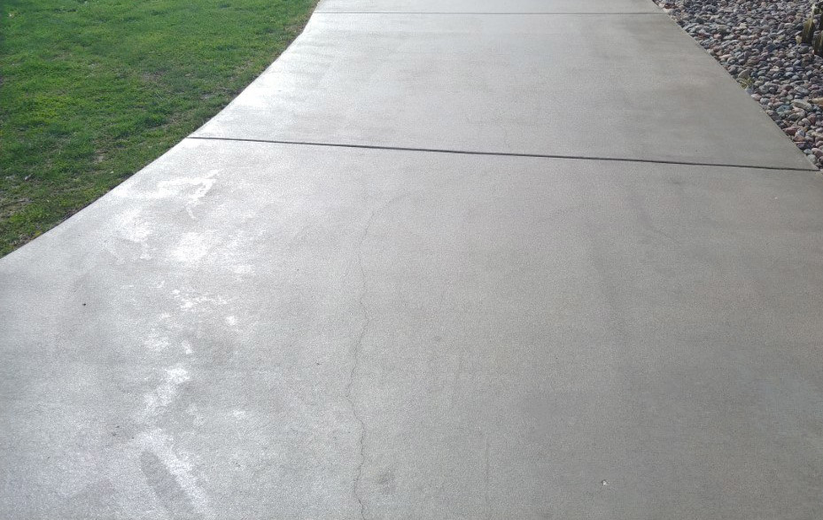 A concrete pathway showing cracks and discoloration, ready for repair or cleaning by JB's Mowing & Misc Services in Aberdeen, SD.