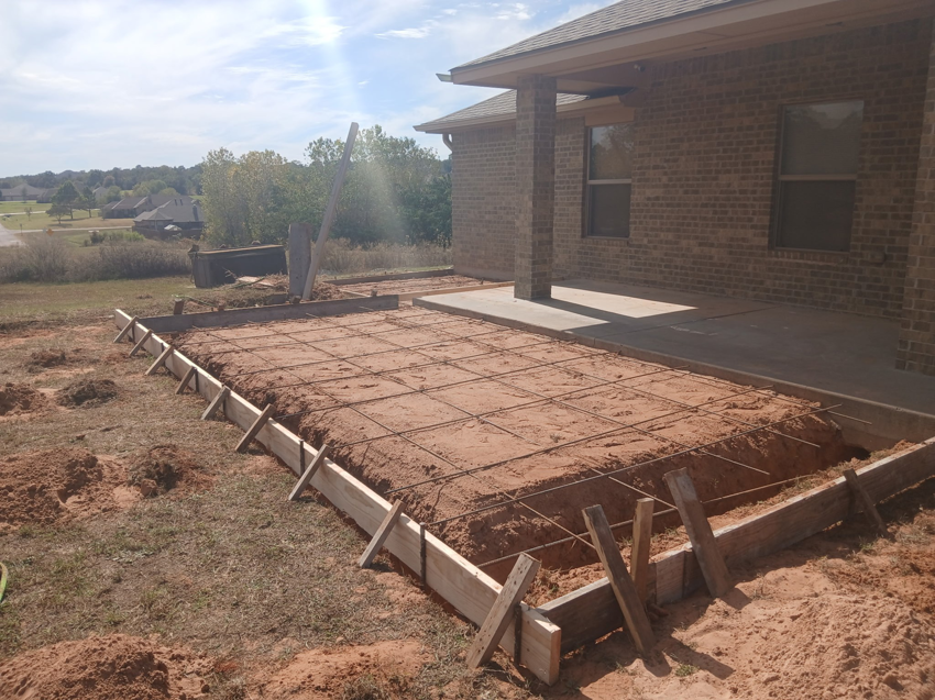 Preparation for a concrete patio foundation with wooden forms and rebar mesh, by All American Concrete in Crescent, OK.
