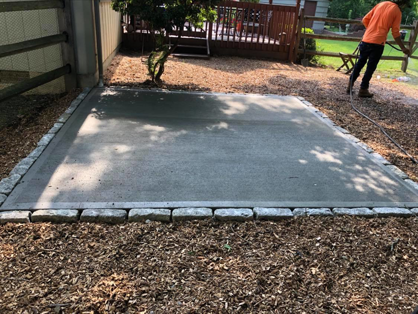 A freshly poured concrete patio slab with a decorative stone border installed by USA Contractors in Danbury, CT.