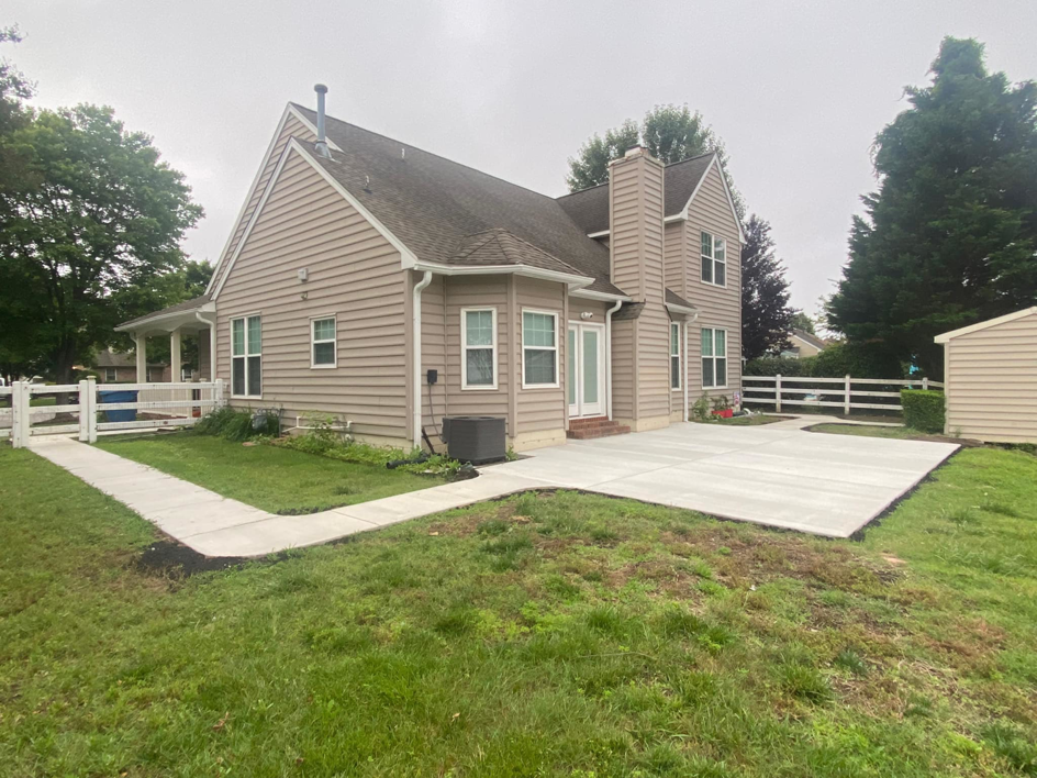 A new concrete patio and walkway installed in a backyard by McGhee's Concrete in Chesapeake, VA.