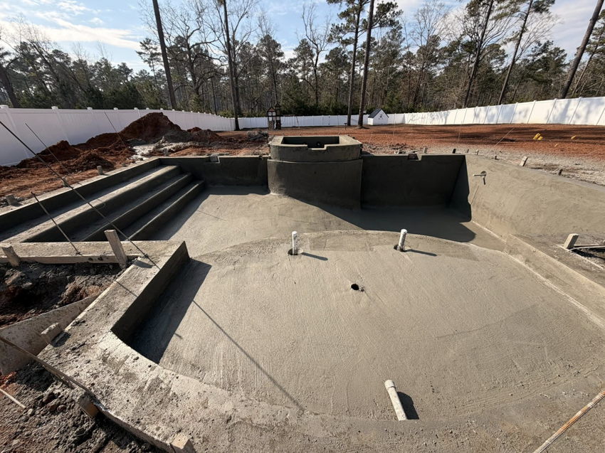 A concrete pool shell with integrated steps and spa area under construction by Ga Impact Shotcrete in Atlanta, GA.