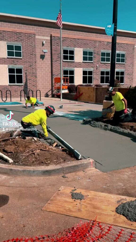 Workers pouring and leveling concrete for a new surface by Solid Rock Builders in Rock Hill, SC.