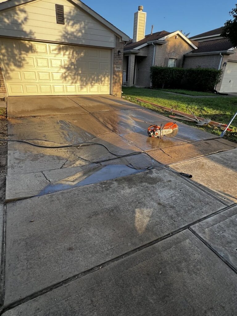 A concrete saw on a residential driveway, indicating concrete cutting work by All Aboard Contractors in Houston, TX.