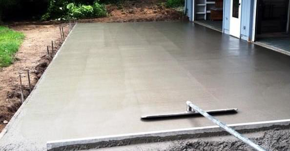 A concrete slab being smoothed with a bull float tool by B&H Homes in Shreveport, LA
