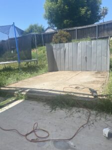 A concrete slab and corrugated metal sheets at a demolition site by Impact Environmental Co. in El Cajon, CA.