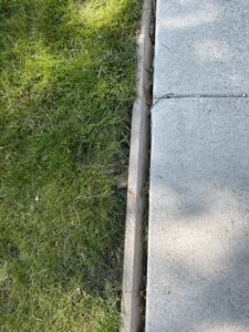 A clean edge of a concrete slab with a wooden border, demonstrating quality work by concrete poured & installed - cp&i in Buffalo, NY.