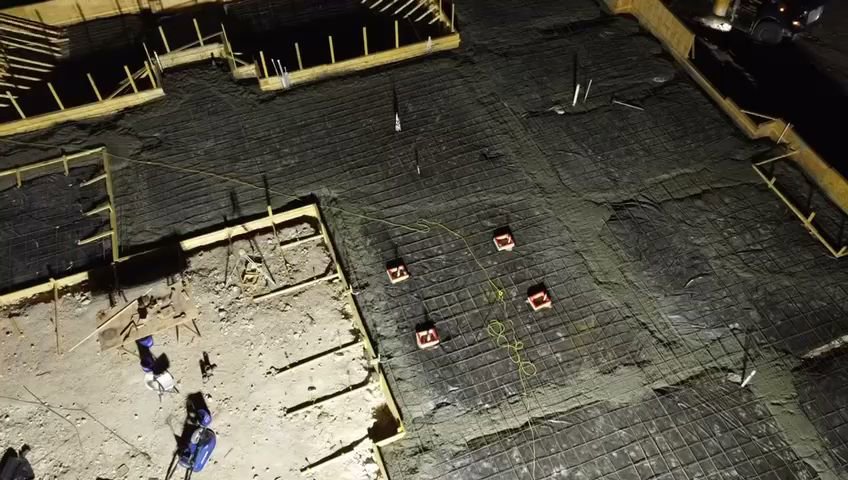 Night view of a concrete slab foundation being prepared with rebar and forms by R and R contractors in Rogers, AR.