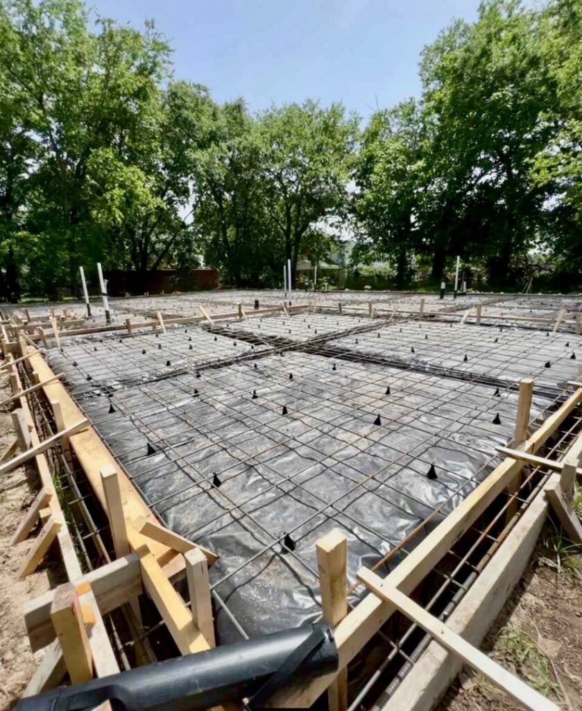 A concrete slab foundation with rebar grid and formwork ready for pouring by Beyond Builders in Tampa, FL