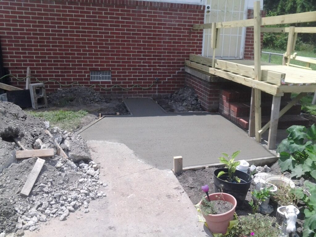 A newly poured concrete slab and wooden ramp construction by The Home Pros in Virginia Beach, VA
