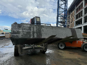 A large concrete slab being removed from a construction site by a heavy machine for Interstate Sawing & Drilling in Yakima, WA.