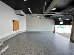 Two workers preparing an outdoor concrete surface with grinding equipment for a general contractor project by Dappa Epoxy Flooring Contractor in Tampa, FL.