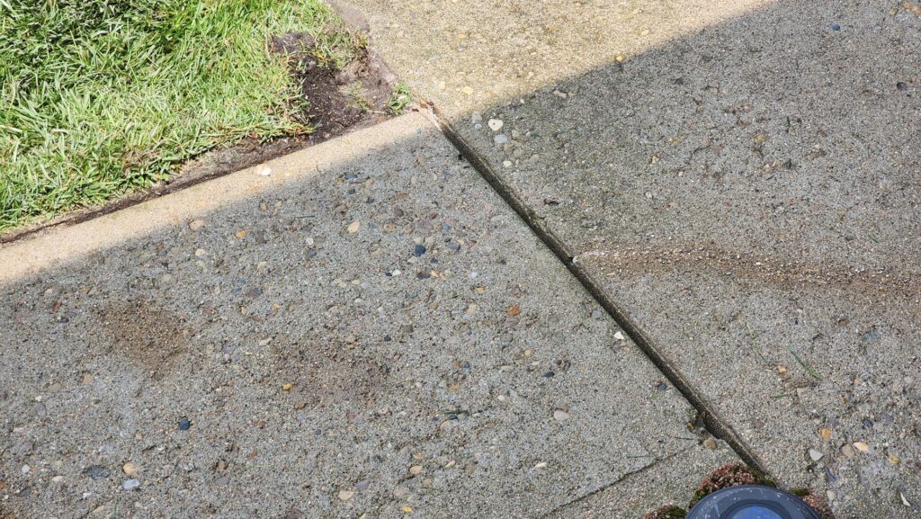 A concrete walkway with small, filled drill holes, indicating a completed concrete leveling service by A1 Concrete Leveling Cincinnati/NKY in Cincinnati, OH.