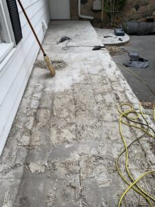 A concrete walkway with old flooring removed, showing surface preparation by The Handy Nevadan LLC in Reno, NV.