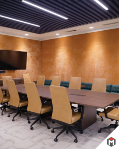 A modern conference room with a large wall-mounted TV, showcasing installation work by Miranda Construction in Louisville, KY.