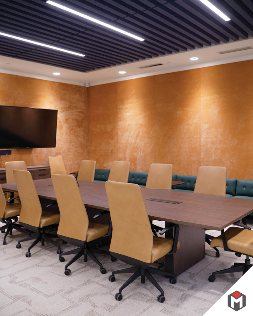 A modern conference room with a large wall-mounted TV, showcasing installation work by Miranda Construction in Louisville, KY.