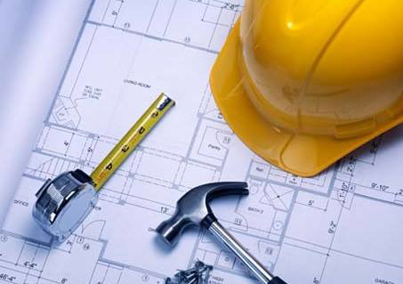 Construction blueprints with a hard hat, tape measure, and hammer, representing MCR Services, Inc. in Merchantville, NJ.