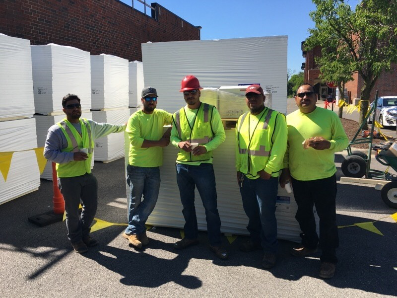A construction crew with materials on a job site by Active Roofing Company in Chicago, IL