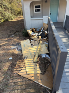A pile of construction debris, wood, and cardboard boxes next to a house, ready for removal by JD Junk Removal in Raleigh, NC.