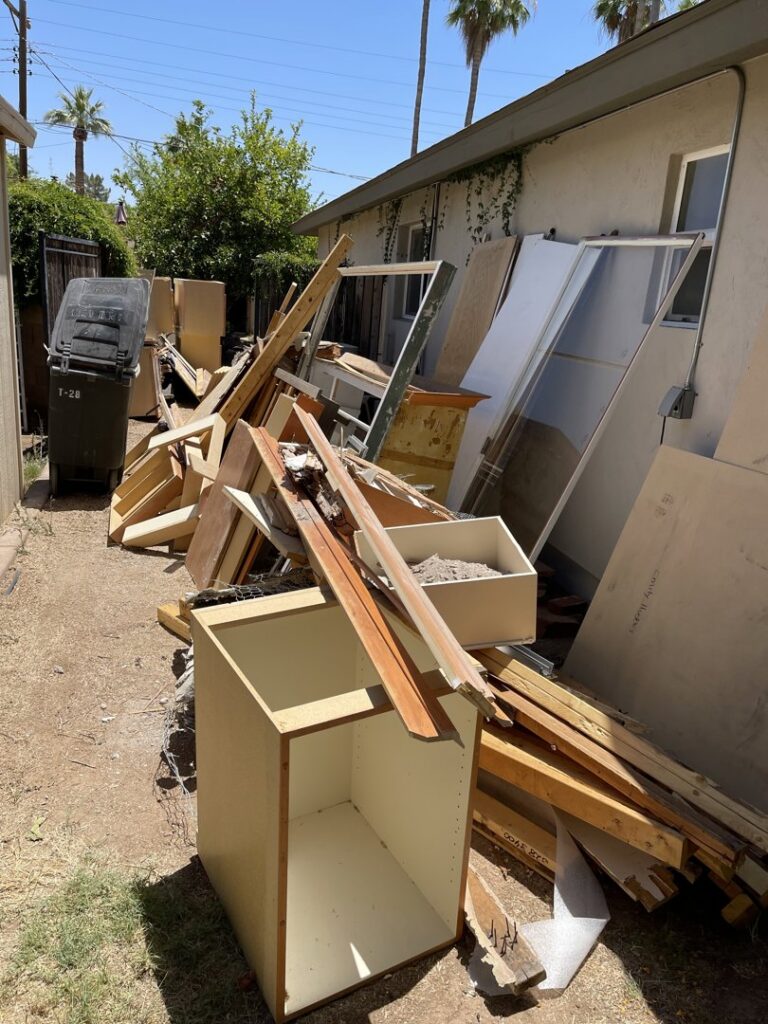A large pile of construction debris, wood, and old cabinets ready for removal by Canyon State Junk Removal in Peoria, AZ