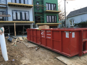 A red roll-off dumpster collecting construction debris for Beck Disposal Inc. in St. Louis, MO