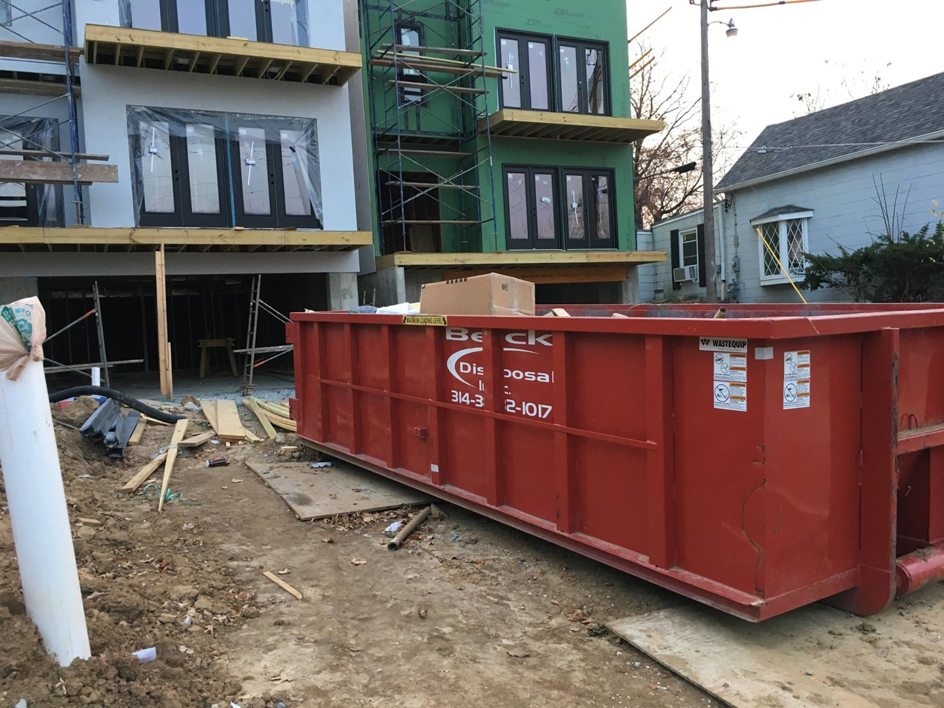 A red roll-off dumpster collecting construction debris for Beck Disposal Inc. in St. Louis, MO