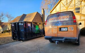 A KC Brothers Disposal dumpster used for construction debris removal next to a contractor's van in Kansas City, MO.