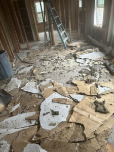 A floor covered in construction debris and broken materials during a renovation, ready for removal by Averson Hauling & Disposal LLC in Lebanon, ME