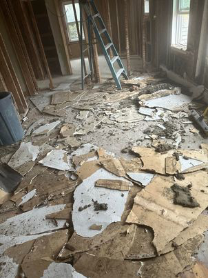 A floor covered in construction debris and broken materials during a renovation, ready for removal by Averson Hauling & Disposal LLC in Lebanon, ME