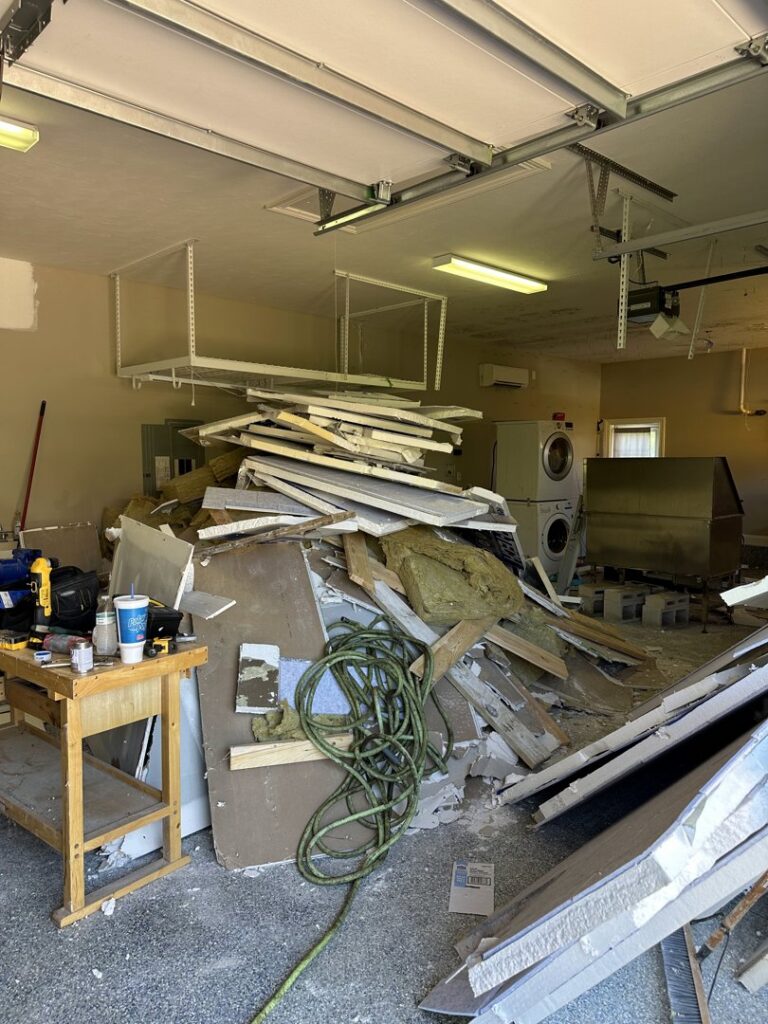 A messy garage filled with construction debris and various junk, awaiting cleanout by Junk Removal JAX in Jacksonville, FL.