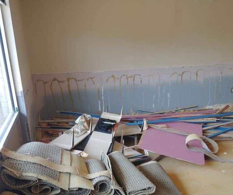 A room filled with construction debris including wood, drywall, and carpet rolls, ready for removal by Omaha Junk Removal in Papillion, NE