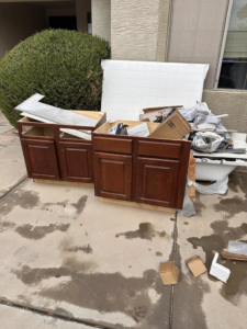 Construction debris including old kitchen cabinets and a bathtub ready for removal by HD Junk Removal in Gilbert, AZ