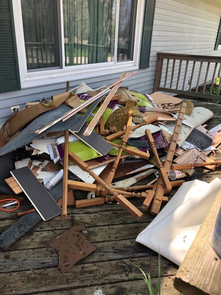 A pile of construction debris and wood scraps on a residential deck, ready for removal by Kaveman Hauling LLC in Ankeny, IA.