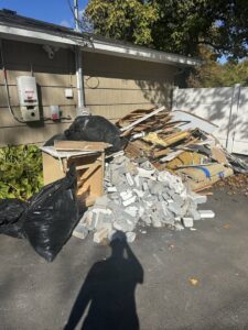 A large pile of construction debris, bricks, wood, and trash bags awaiting removal by Junk Beasts LLC in Marlborough, MA