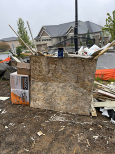 A large pile of construction debris, including plywood and wood scraps, ready for junk removal by Xtreme Haul in Vancouver, WA.