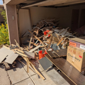 A garage filled with construction debris and wood scraps, ready for removal by J & R Junk Removal in Phoenix, AZ.
