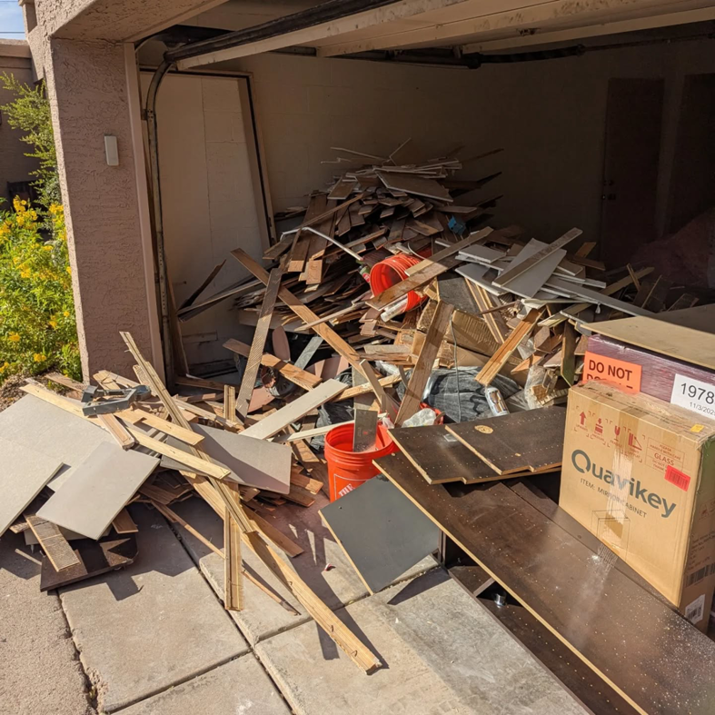 A garage filled with construction debris and wood scraps, ready for removal by J & R Junk Removal in Phoenix, AZ.