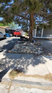 A pile of construction debris, possibly roof tiles, under a tree awaiting removal by Las Vegas Hauling Junk & Moving in Las Vegas, NV