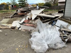A large pile of construction and demolition debris, including drywall and insulation, ready for removal by Primetime Hauling and Junk Removal in Spokane, WA.