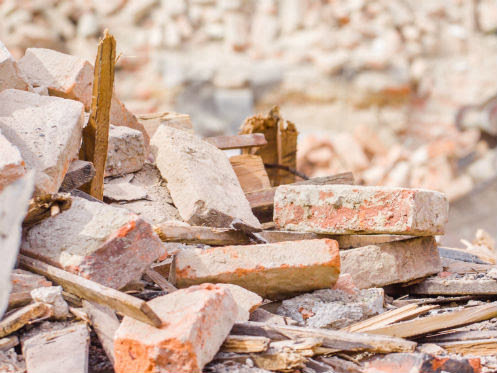 A pile of broken bricks and wood debris from construction or demolition, ready for removal by Trashouts Junk Removal in Pembroke Pines, FL.