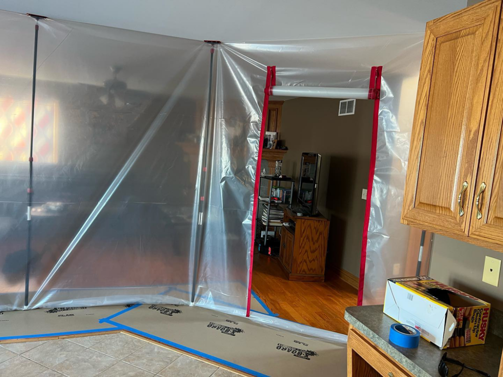 Interior view of a home with plastic sheeting for construction dust protection by Silhouette Builders, Inc. in Yorkville, IL