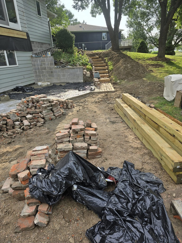 Construction materials for a landscaping project, including bricks and lumber, by PRO HANDY FIXER in Kearney, NE.